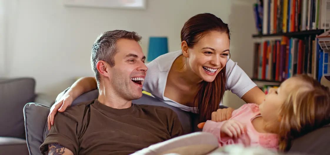 Família sorrindo no sofá